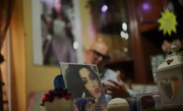 Angelo Venturato talks during an interview with the Associated Press next to photos of his daughter Maria who died at the age of 25 of a cancer he claims to be connected to decades of pollution from illegal waste dumping and burning, much of it linked to organized criminal groups, in the southern town of Acerra, Friday, May 22, 2026. (AP Photo/Andrew Medichini)