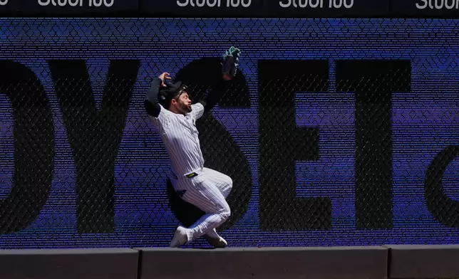 New York Yankees' Jasson Domínguez is injured while catching a ball hit by Texas Rangers' Brandon Nimmo for an out during the first inning of a baseball game Thursday, May 7, 2026, in New York. (AP Photo/Frank Franklin II)