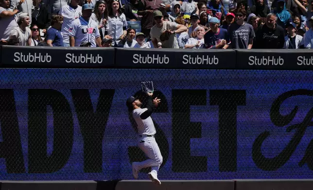 New York Yankees' Jasson Domínguez is injured while catching a ball hit by Texas Rangers' Brandon Nimmo for an out during the first inning of a baseball game Thursday, May 7, 2026, in New York. (AP Photo/Frank Franklin II)