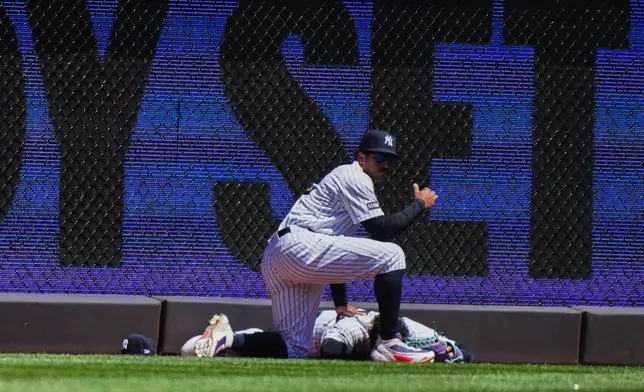 New York Yankees' Jasson Domínguez is injured while catching a ball hit by Texas Rangers' Brandon Nimmo for an out during the first inning of a baseball game Thursday, May 7, 2026, in New York. (AP Photo/Frank Franklin II)