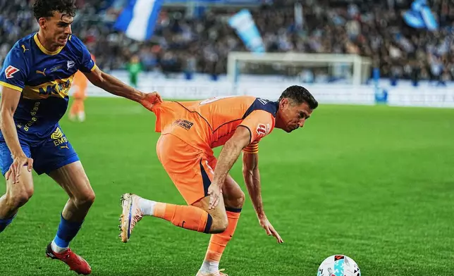 Barcelona's Robert Lewandowski, right, and Alaves' Angel Perez fight for the ball during the Spanish La Liga soccer match between Alaves and Barcelona in Vitoria-Gasteiz, Spain, Wednesday, May 13, 2026. (AP Photo/Miguel Oses)