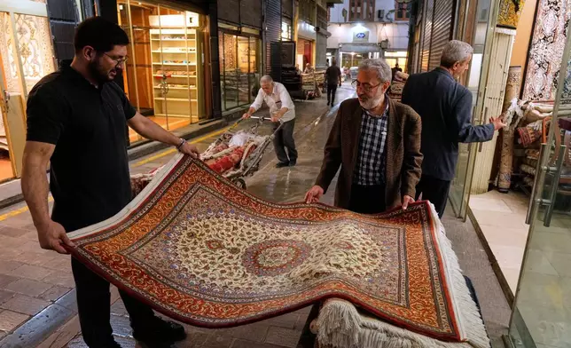 People view rugs at the Grand Bazaar in Tehran, Sunday, May 3, 2026. (AP Photo/Vahid Salemi)