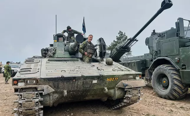 Swedish servicemen looks out of an armoured vehicle during a military exercises in Gotland, Sweden, Monday, May 11, 2026. (AP Photo/Emma Burrows)