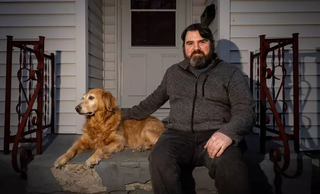 Dustin Wood, a former English teacher at the Calo Programs Residential Treatment Center, poses with his dog Moana, a former Calo therapy dog, on Feb 25, 2026, outside his home in Eldon, Mo. (AP Photo/Austin Johnson)