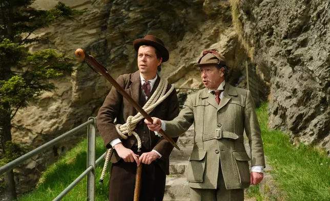 Martin Iggland, left, as Melchior Anderegg and Philip Porter, as, Sherlock Holmes during an event recreating the fateful confrontation between Sherlock Holmes and Professor Moriarty by the members of the Sherlock Holmes Society of London, at the Reichenbach Falls, Switzerland, May 3, 2026. (AP Photo/Niccolo Lupone, Pool)