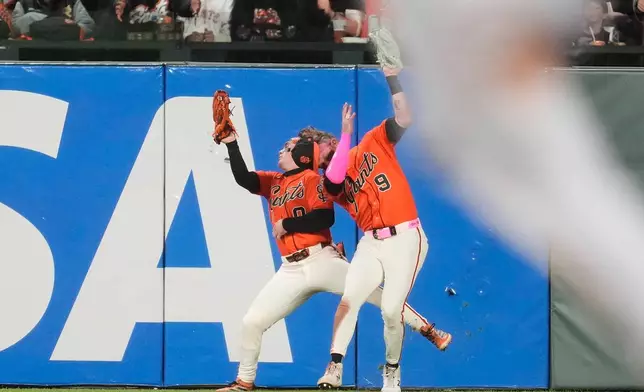 San Francisco Giants center fielder Harrison Bader (9) catches a fly ball hit by Chicago White Sox's Andrew Benintendi next to right fielder Drew Gilbert, left, during the seventh inning of a baseball game Friday, May 22, 2026, in San Francisco. (AP Photo/Jeff Chiu)