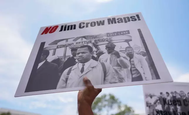 A protestor holds a sign of the late Georgia Congressman John Lewis during a voting rally, Saturday, May 16, 2026, in Montgomery, Ala. (AP Photo/Mike Stewart)