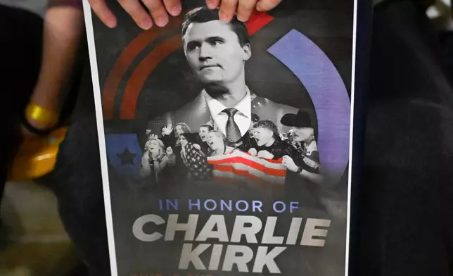 FILE - An attendee holds a poster of Charlie Kirk during a Turning Point USA rally, Sept. 30, 2025, in Logan, Utah. (AP Photo/Alex Goodlett, File)