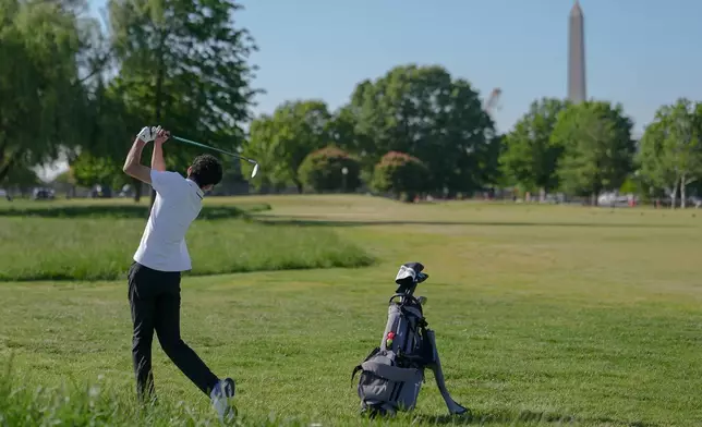 The Washington Monument stands in the background as Roman Sandoli swings at the East Potomac Golf Course, Sunday, May 3, 2026, in Washington. (AP Photo/Julia Demaree Nikhinson)