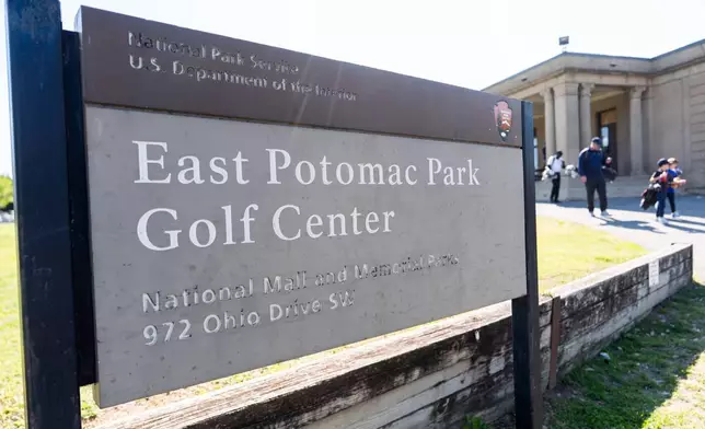 People walk past a sign at the entrance of East Potomac Golf Course, Sunday, May 3, 2026, in Washington. (AP Photo/Julia Demaree Nikhinson)