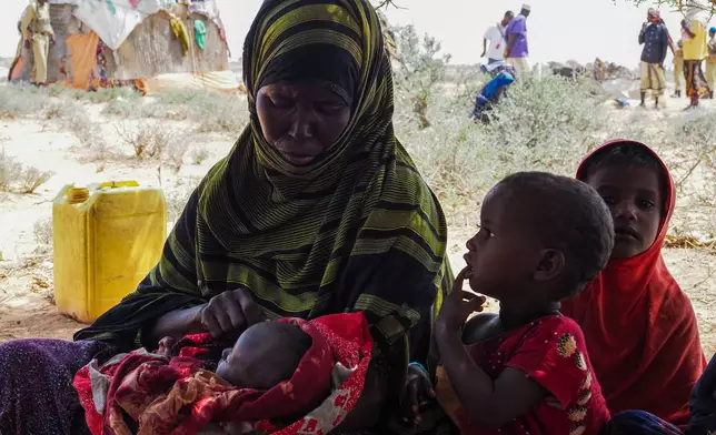 Abdi Ahmed Farah's wife, Absheera Ali, sits with her children outside their home in Usgure, Puntland, Somalia, Wednesday, April 15, 2026. (AP Photo/Jack Denton)
