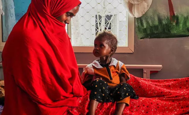 A mother looks at her daughter, who is suffering from severe acute malnutrition, at a stabilization center in a hospital in Qardho, Puntland, Somalia, Friday, April 17, 2026. (AP Photo/Jack Denton)