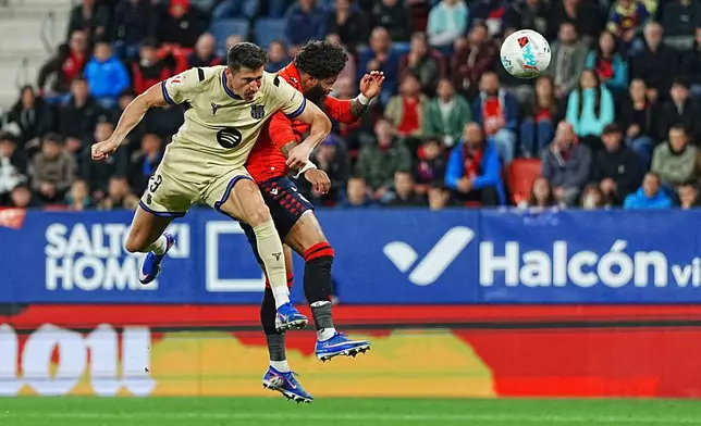Barcelona's Robert Lewandowski heads the ball to score his side's opening goal during a Spanish La Liga soccer match between Osasuna and Barcelona in Pamplona, Spain, Saturday, May 2, 2026. (AP Photo/Miguel Oses)