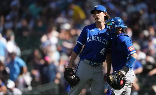 Kansas City Royals relief pitcher Daniel Lynch IV, left, greets catcher Carter Jensen, right, as they celebrate a win over the Seattle Mariners in a baseball game, Sunday, May 3, 2026, in Seattle. (AP Photo/Lindsey Wasson)