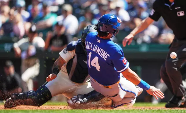 Kansas City Royals' Jac Caglianone scores on an RBI double from Isaac Collins in front of Seattle Mariners catcher Jhonny Pereda during the sixth inning of a baseball game, Sunday, May 3, 2026, in Seattle. (AP Photo/Lindsey Wasson)