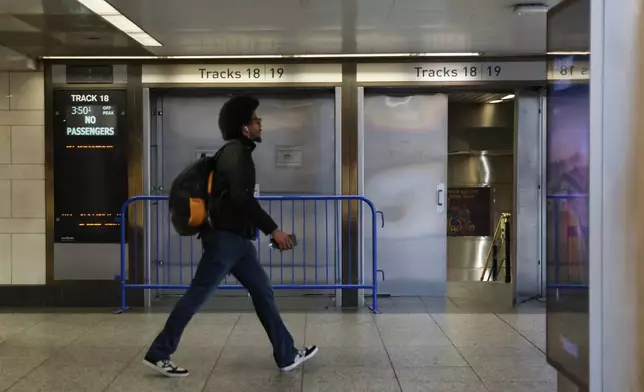 A pedestrian walks past closed off tracks inside Penn Station on the first day of a Long Island Rail Road strike, Saturday, May 16, 2026, in New York. (AP Photo/Heather Khalifa)