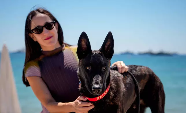 Dominga Sotomayor, left, director of the film "La Perra" poses with Apocalypse after accepting the palm dog award on behalf of Yuri, who could not attend, at the end the Palm Dog award ceremony at the 79th international film festival, Cannes, southern France, Friday, May 22, 2026. (AP Photo/Andreea Alexandru)