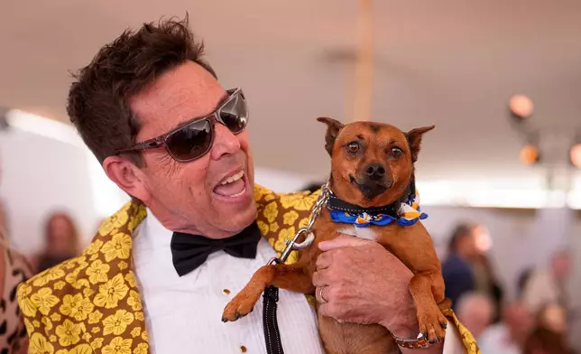 A person holds Tino, 5 years old, during the Palm Dog award ceremony at the 79th international film festival, Cannes, southern France, Friday, May 22, 2026. (AP Photo/Andreea Alexandru)