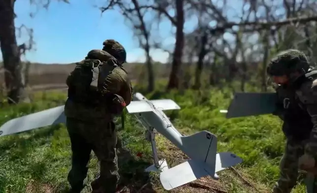 In this image made from video provided by Russian Defense Ministry Press Service on Wednesday, May 27, 2026., Russian servicemen prepare to launch an interceptor drone for an action in an undisclosed location in Ukraine. (Russian Defense Ministry Press Service via AP)