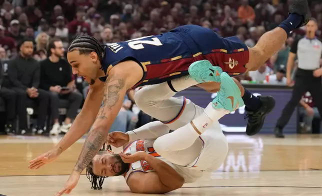 Cleveland Cavaliers guard Jaylon Tyson (20) collides with New York Knicks guard Jalen Brunson (11) during the first half of Game 4 in the Eastern Conference finals NBA basketball playoffs series in Cleveland, Monday, May 25, 2026. (AP Photo/Sue Ogrocki)