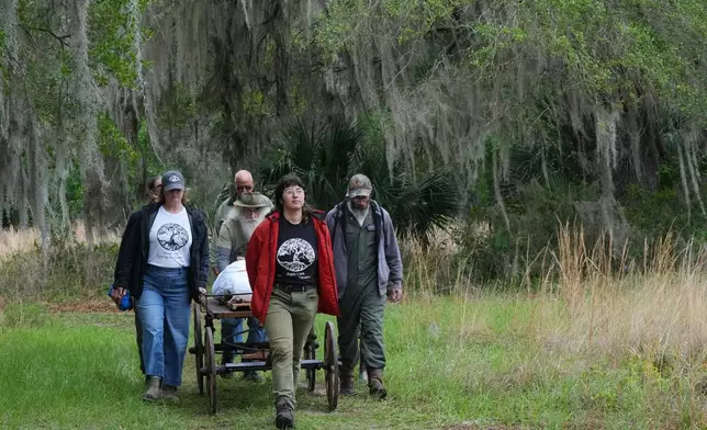 Carly Zeffren, with the Prairie Creek Conservation Cemetery, brings the body of Kenneth Jennings King to his grave site Tuesday, April 7, 2026, in Gainesville, Fla. (AP Photo/Marta Lavandier)