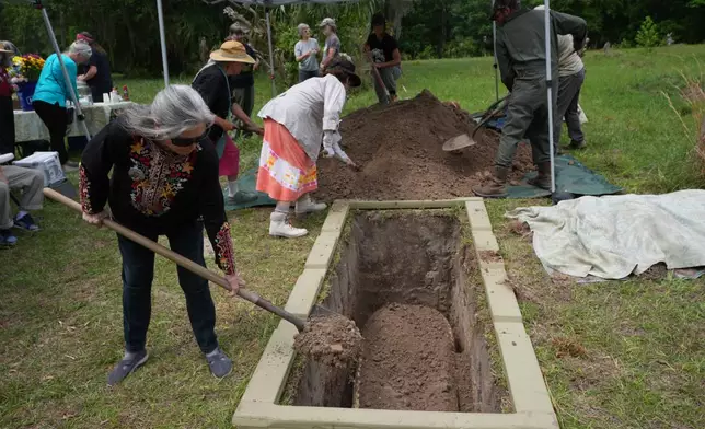 Friends and family help bury the body of Jacqueline Betz at the Prairie Creek Conservation Cemetery, Monday, April 6, 2026, in Gainesville, Fla. (AP Photo/Marta Lavandier)