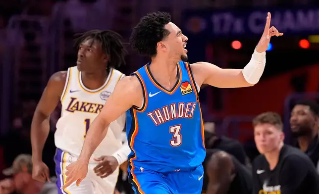 Oklahoma City Thunder guard Jared McCain, right, gestures after scoring as Los Angeles Lakers forward Adou Thiero runs behind during the first half of Game 3 in a second-round NBA basketball playoffs series Saturday, May 9, 2026, in Los Angeles. (AP Photo/Mark J. Terrill)