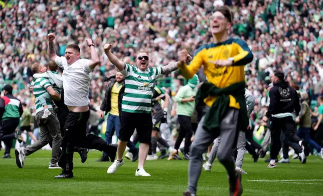 Celtic fans invade the pitch at full time following following the Scottish Premiership soccer match against Heart of Midlothian in Glasgow, Scotland, Saturday, May 16, 2026. (Andrew Milligan/PA via AP)