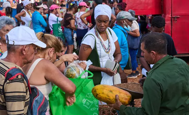 People line up to buy papaya at a weekly food fair in Alamar, Havana province, Cuba, Saturday, May 2, 2026. (AP Photo/Ramon Espinosa)