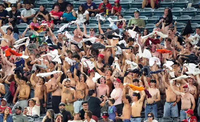 Fans chant with their shirts off in right field during the eighth inning of a baseball game between the Los Angeles Angels and the Athletics, Wednesday, May 20, 2026, in Anaheim, Calif. (AP Photo/Mark J. Terrill)
