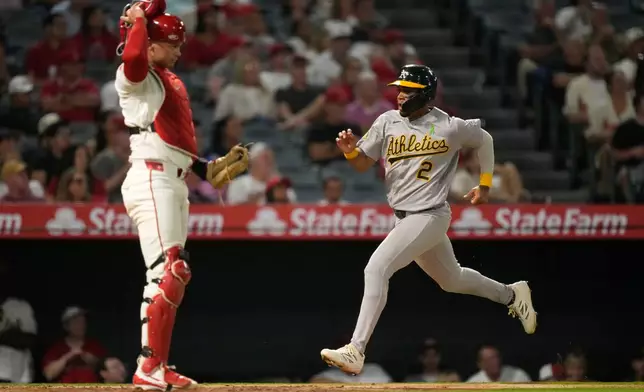 Athletics' Darell Hernaiz, right, scores on a single by Nick Kurtz as Los Angeles Angels catcher Logan O'Hoppe stands by during the seventh inning of a baseball game Wednesday, May 20, 2026, in Anaheim, Calif. (AP Photo/Mark J. Terrill)