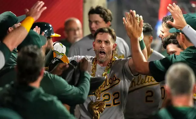 Athletics' Jeff McNeil is congratulated by teammates in the dugout after hitting a solo home run during the ninth inning of a baseball game against the Los Angeles Angels, Wednesday, May 20, 2026, in Anaheim, Calif. (AP Photo/Mark J. Terrill)
