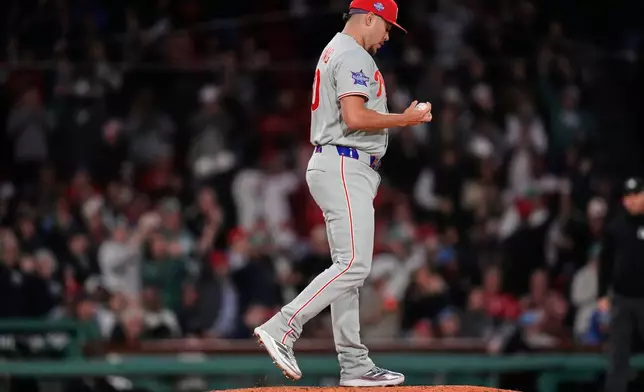 Philadelphia Phillies pitcher Orion Kerkering looks down at a fresh baseball after giving up a two-run home run to Boston Red Sox's Ceddanne Rafaela during the sixth inning of a baseball game, Wednesday, May 13, 2026, in Boston. (AP Photo/Charles Krupa)
