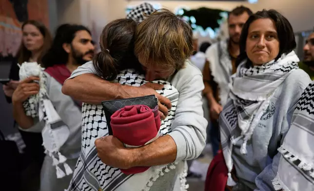 Activists from the Global Sumud Flotilla comfort each other upon their arrival at Istanbul Airport, in Istanbul, Turkey, Thursday, May 21, 2026. (AP Photo/Emrah Gurel)
