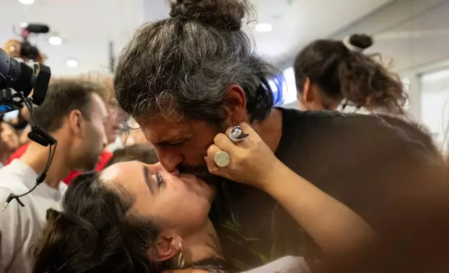 An activist from the Global Sumud Flotilla kisses a woman upon his arrival at Eleftherios Venizelos International Airport in Athens, Greece, Friday, May 22, 2026. (AP Photo/Michael Varaklas)