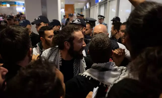 An activist from the Global Sumud Flotilla talks with the police upon his arrival at Eleftherios Venizelos International Airport in Athens, Greece, Friday, May 22, 2026. (AP Photo/Michael Varaklas)