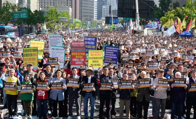 Members of the Korean Confederation of Trade Unions stage a rally on May Day in Seoul, South Korea, Friday, May 1, 2026. The letters read "No War and Peace." (AP Photo/Ahn Young-joon)