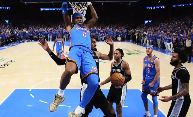 Oklahoma City Thunder guard Shai Gilgeous-Alexander (2) dunks against San Antonio Spurs forward Victor Wembanyama (1) during the first half of Game 1 in a third-round NBA basketball playoffs series Monday, May 18, 2026, in Oklahoma City. (AP Photo/Nate Billings)