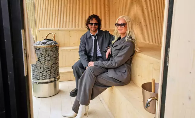 Linda Lampenius and Pete Parkkonen, who compete as Liekinheitin for Finland at the 70th Eurovision Song Contest, sit in a Finnish sauna after an interview with The Associated Press in Vienna, Austria, Thursday, May 14, 2026. (AP Photo/Martin Meissner)