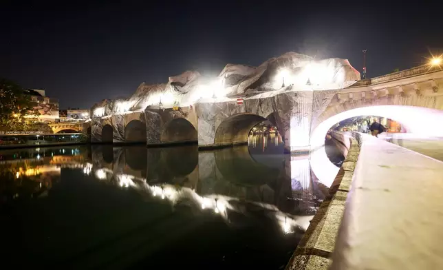 Inflation of the artwork "The Pont Neuf Cave" by French street artist JR on the Pont Neuf bridge, Thursday, May 21, 2026, in Paris, before its free opening to the public from June 6 to 28. (AP Photo/Thomas Padilla)