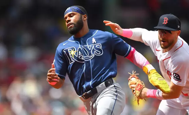 Tampa Bay Rays' Cedric Mullins, left, tries to elude Boston Red Sox shortstop Trevor Story, right, before being tagged in a rundown in the fourth inning of a baseball game, Sunday, May 10, 2026, in Boston. (AP Photo/Steven Senne)