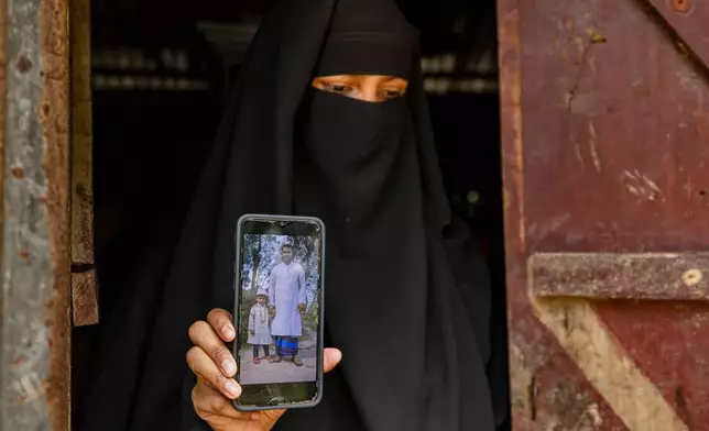 Sadia Islam Sarmin, the wife of Mohammad Abdullah Al Mamun, shows a photo of her late husband and their son on a mobile phone in Rasulpur village, Mymensingh district, Bangladesh, Friday, April 17, 2026. (AP Photo/Rajib Dhar)