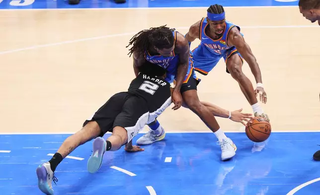San Antonio Spurs guard Dylan Harper (2) battles for a loose ball against Oklahoma City Thunder guard Cason Wallace (22) and guard Shai Gilgeous-Alexander (2) in the second half of Game 7 of the Western Conference finals of the NBA basketball playoffs series Saturday, May 30, 2026, in Oklahoma City. (AP Photo/Nate Billings)