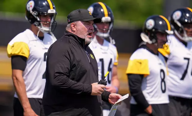 Pittsburgh Steelers head coach Mike McCarthy, second from left, gives instructions with quarterbacks Mason Rudolph, left, Drew Allar, center, and Aaron Rodgers, (8) waiting their turn to run a drill during the football team's OTA workout in Pittsburgh, Monday, May 18, 2026. (AP Photo/Gene J. Puskar)