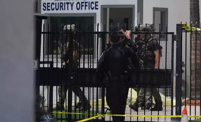 A body is covered with a tarp at the scene of a shooting outside the Islamic Center of San Diego Monday, May 18, 2026, in San Diego. (AP Photo/Gregory Bull)