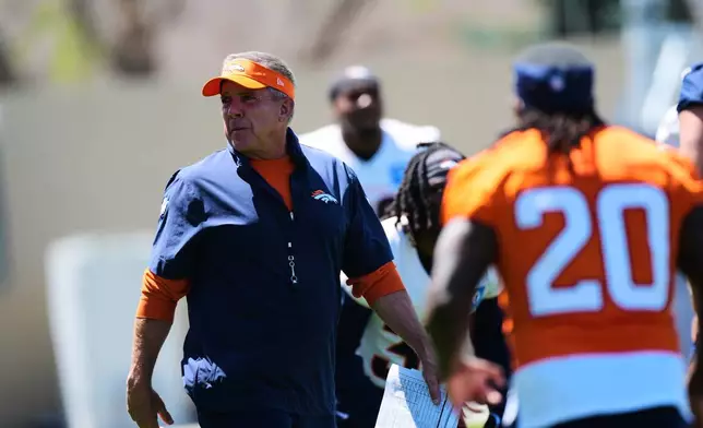 Denver Broncos head coach Sean Payton, left, looks on as rookies and free agents stretch before during drills at the NFL football team's rookie minicamp Saturday, May 9, 2026, at the team's headquarters in Centennial, Colo. (AP Photo/David Zalubowski)