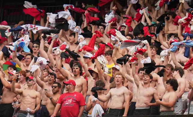 Fans cheer and wave their shirts above their heads during the fifth inning of a baseball game between the St. Louis Cardinals and the Kansas City Royals Saturday, May 16, 2026, in St. Louis. (AP Photo/Jeff Roberson)
