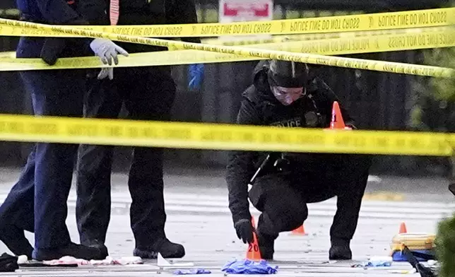 U.S. Secret Service Police place evidence markers on a crime scene after responding to reports of shots fired near the White House, Saturday, May 23, 2026, in Washington. (AP Photo/Alex Brandon)