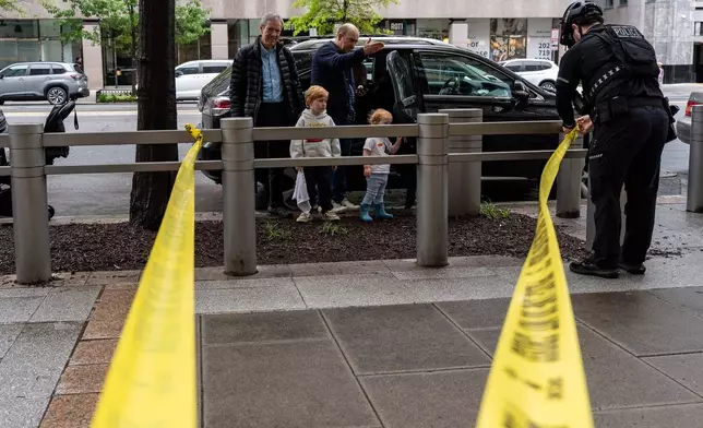 People watch as U.S. Secret Service Police place crime scene tape after a copper jacket of a bullet was found near the scene of a shooting close to the White House, Sunday, May 24, 2026, in Washington. (AP Photo/Alex Brandon)