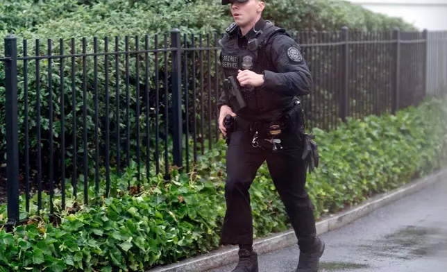 A secret service police officer runs at the White House, Saturday, May 23, 2026, in Washington. (AP Photo/Jose Luis Magana)